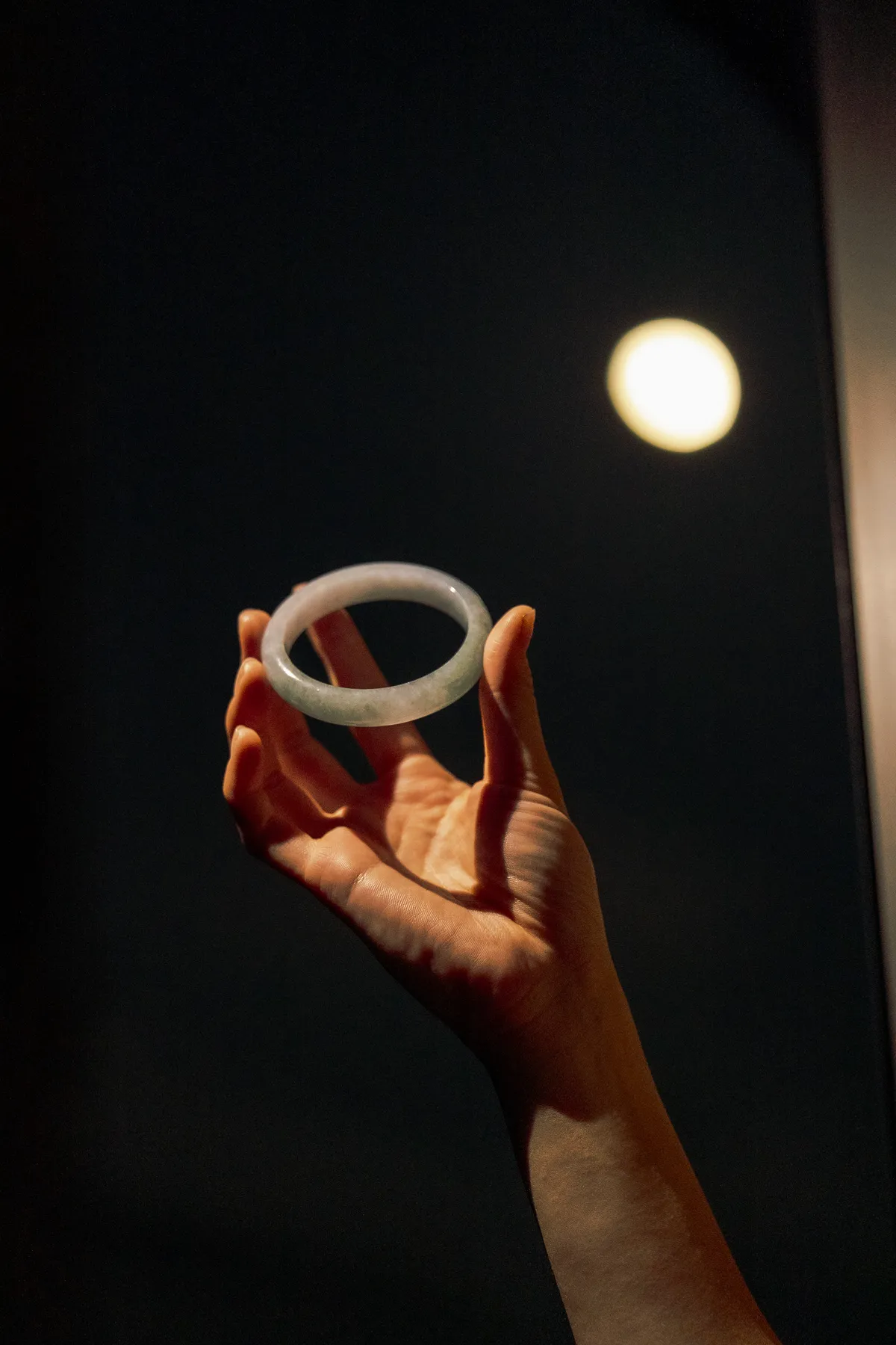 A carved bangle held up to the moon