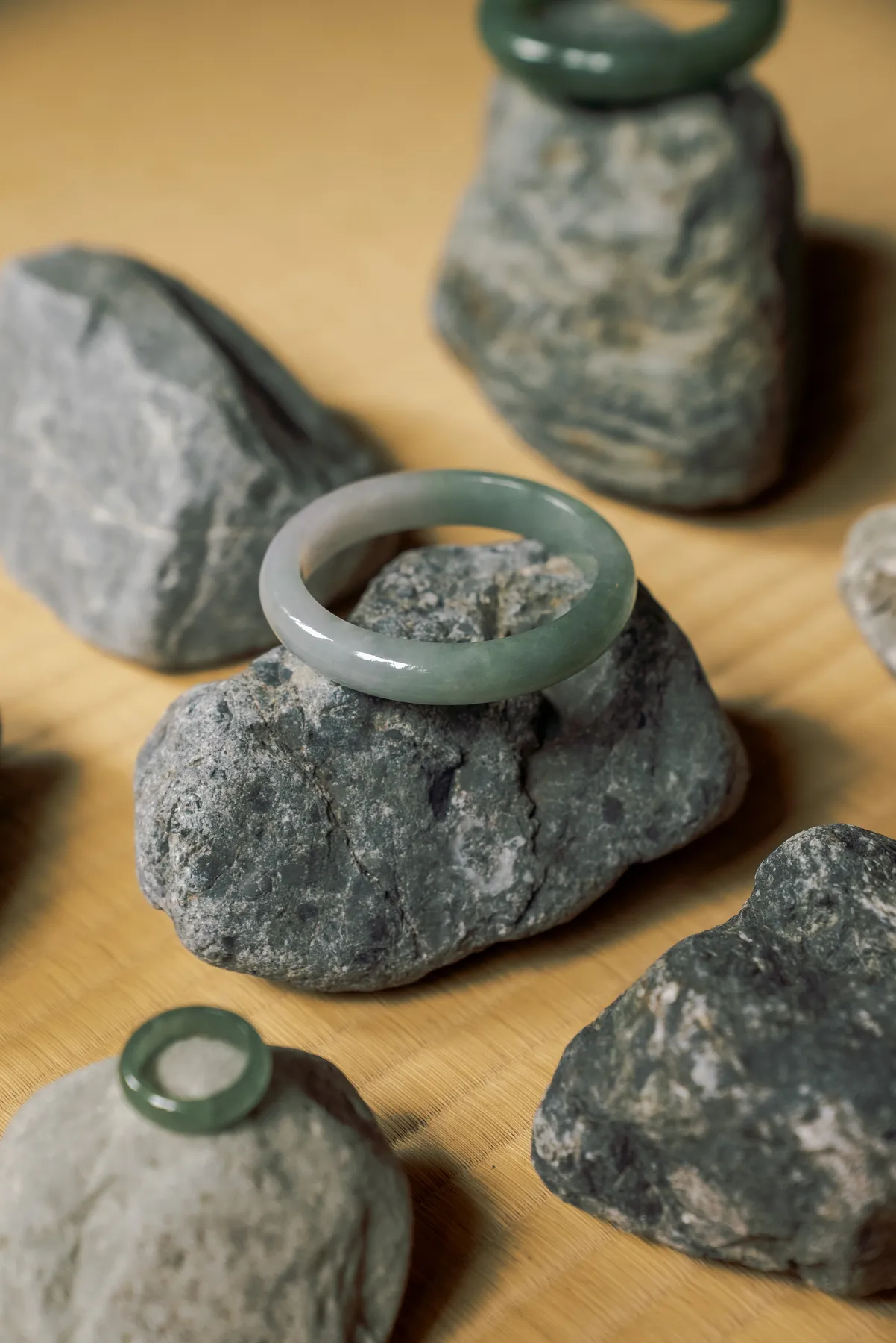 Carved jade bangles and rings resting on stone