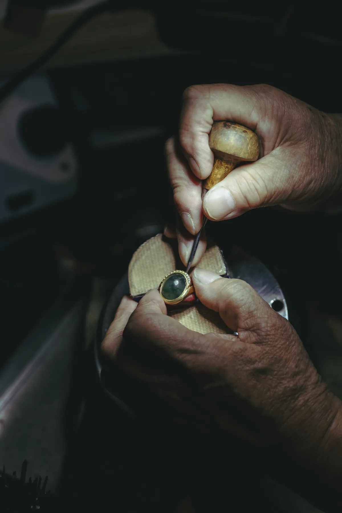 The jeweler setting a jade stone by hand