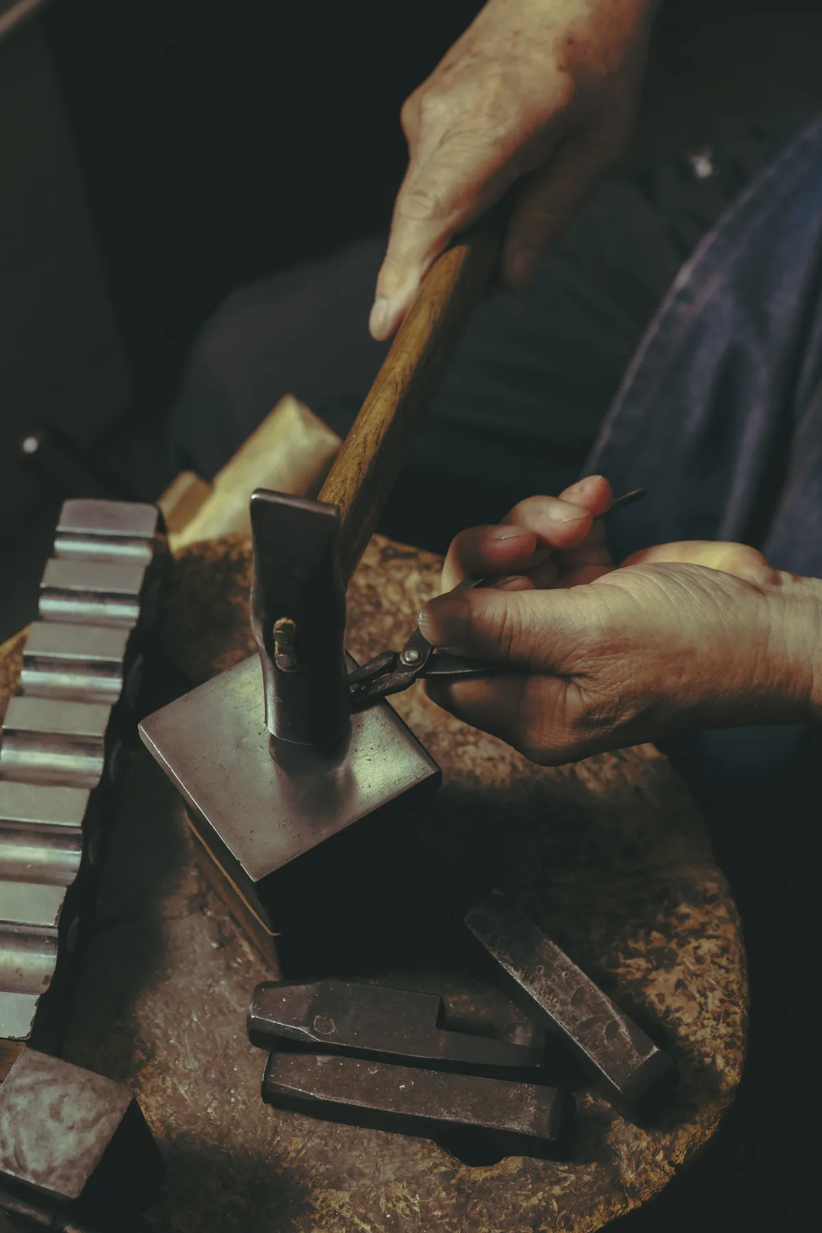 The jeweler's hands at the bench, hammer and stakes