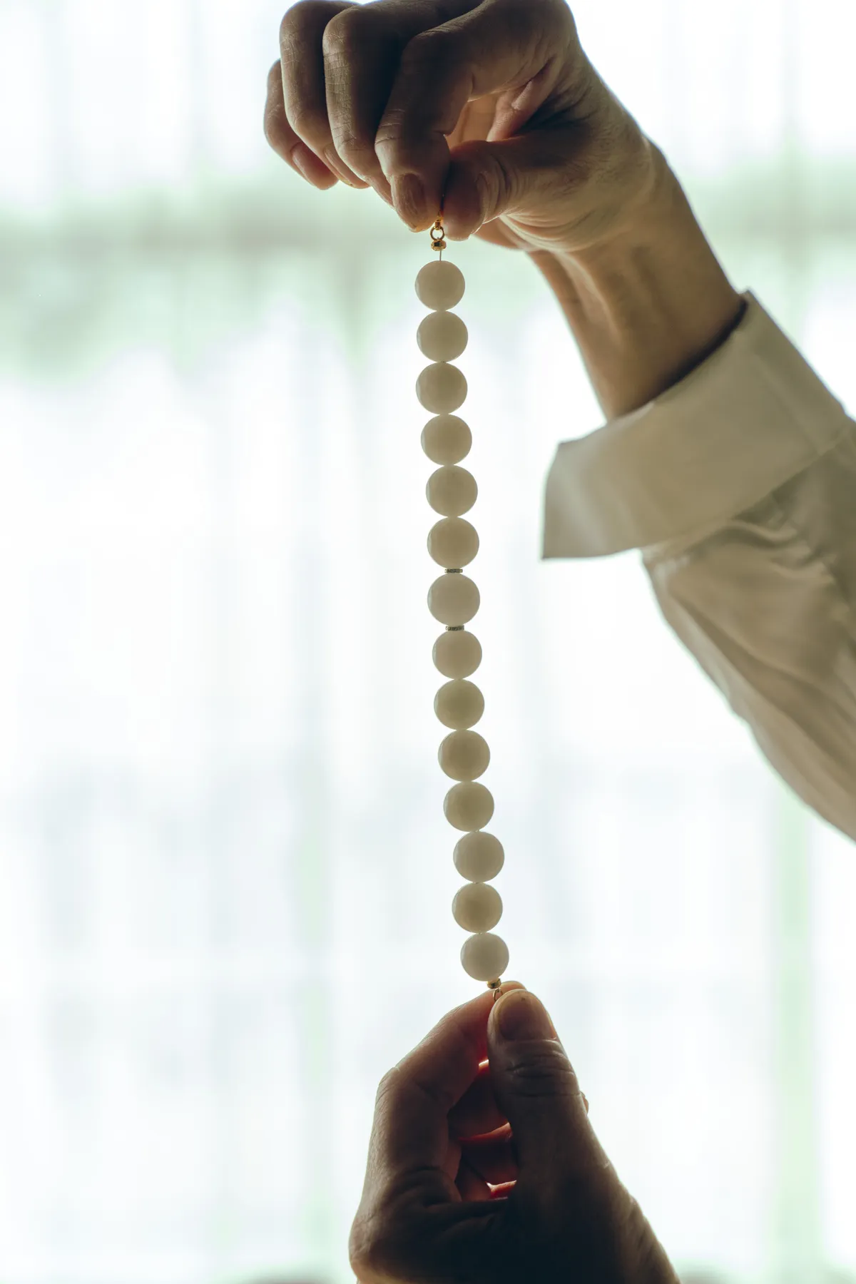 Jade beads held to the light